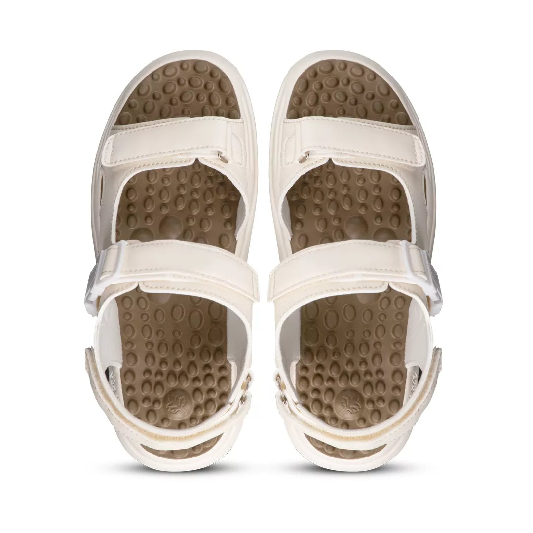Pair of beige sandals with textured soles on a white background