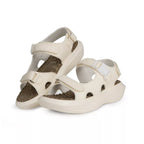 Pair of beige sandals with brown soles on a white background