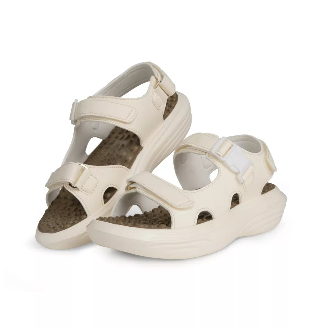 Pair of beige sandals with brown soles on a white background