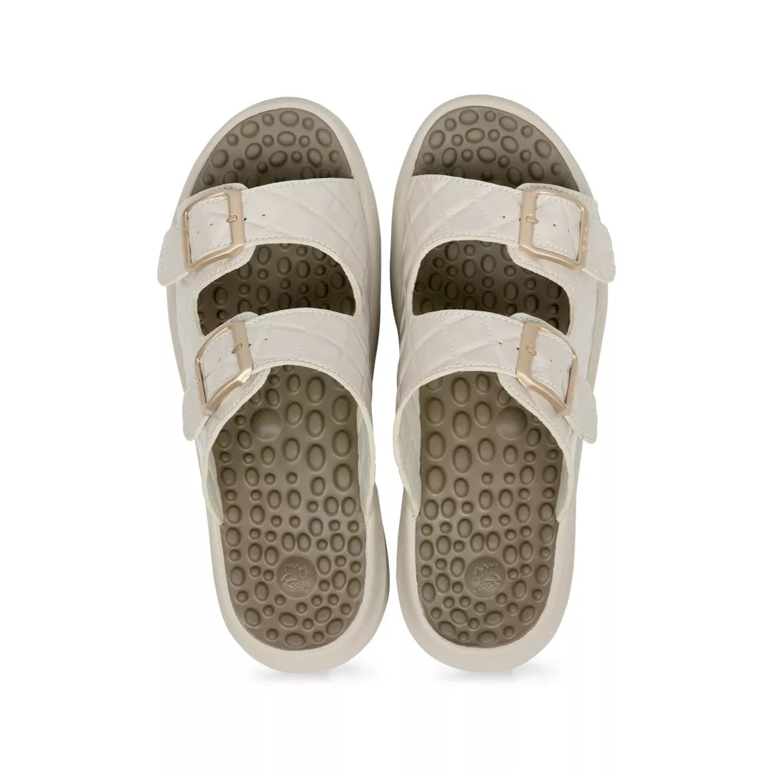 Pair of beige sandals with textured soles on a white background